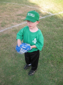 Playing his position (I think "left short stop" - they have that in tee-ball I guess)